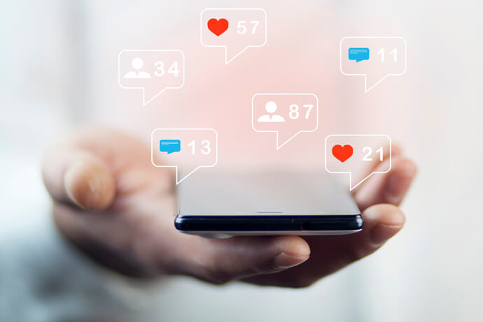 An image of a person with a mobile phone showcasing notifications from apps
